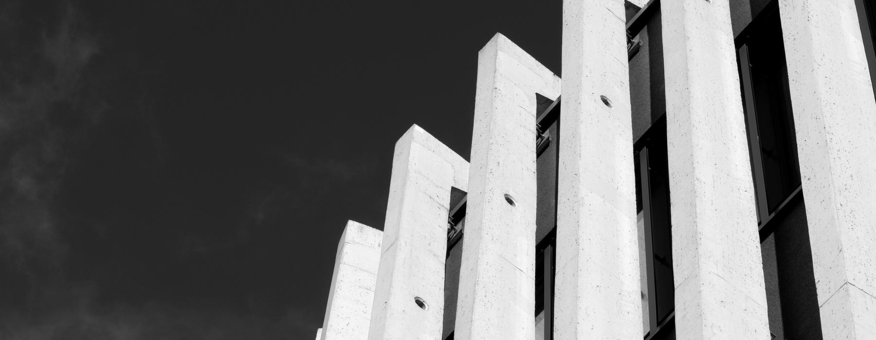 Concrete fins of a modernist building against a dark sky