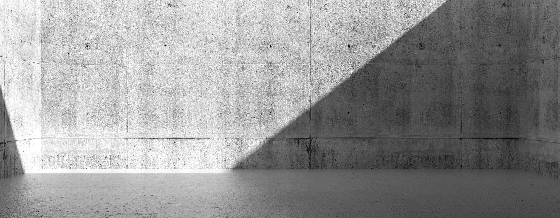 A bare concrete room lit from one opening